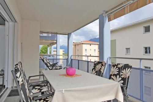 a table on a balcony with a pink vase on it at Casa ai Faggi, 3-Zimmerwohnung, 3 Stock by HolAp SA in Losone