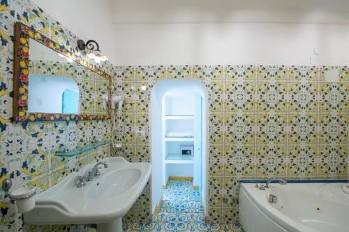 a bathroom with a sink and a mirror and a tub at Hotel Costa Diva in Praiano