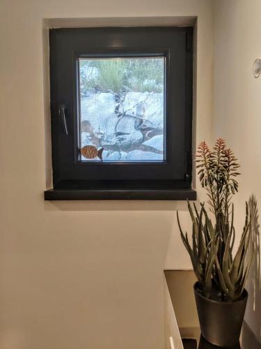 a television sitting on a wall with a plant at Sea view BluEscape by Vellaris, Luxury Mobile Home in Mali Lošinj