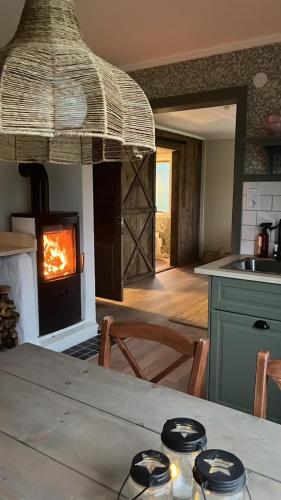 a kitchen with a table with a fireplace in it at Olletorp in Munkedal