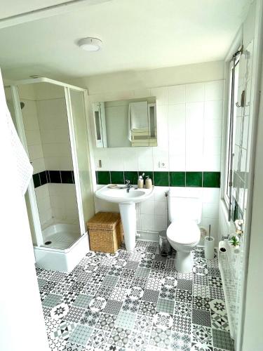 une salle de bain blanche avec un lavabo et des toilettes dans l'établissement La Longère au Puits, au Tilleul