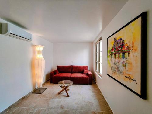 - un salon avec un canapé rouge et une fenêtre dans l'établissement Saint Germain - Séjour à Auxerre, à Auxerre