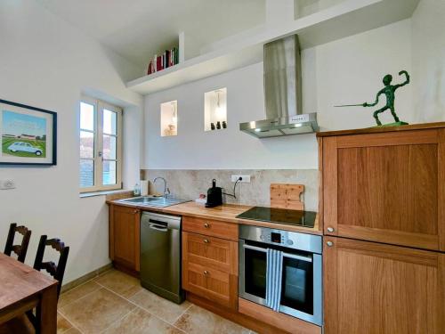 Il comprend une cuisine équipée d'une cuisinière. four supérieur à côté d'une table dans l'établissement Saint Germain - Séjour à Auxerre, à Auxerre