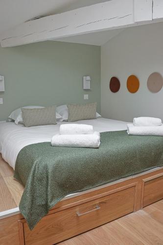 - une chambre avec un grand lit et une couverture verte dans l'établissement Le Patio Secret - Elégance en Centre Ville, à Bordeaux