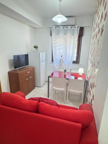 Una sala de estar con un sofá rojo y una mesa. en Casa Ponticello, en Termini Imerese