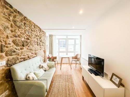 a living room with a couch and a table at Casa de Ángeles by ALÔGA in Fisterra