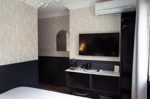 a bedroom with a sink and a tv on the wall at La Caravelle in Aix-en-Provence