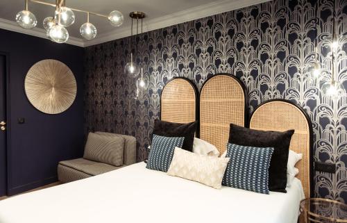 a bedroom with a bed with pillows and a chair at La Caravelle in Aix-en-Provence