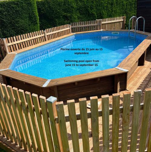 une piscine entourée d'une clôture en bois. dans l'établissement Maison du Lavoir Disneyland, à Bailly-Romainvilliers