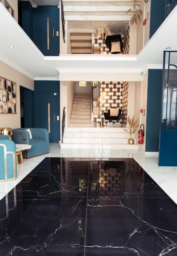 a lobby with a black marble floor and blue walls at La Caravelle in Aix-en-Provence