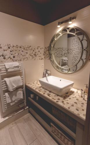 une salle de bain avec un lavabo et un miroir dans l'établissement Domaine de la Baratonne, à La Garde
