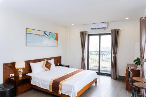 a hotel room with a bed and a balcony at WILD HORSE Hotel - Khách sạn biển Hải Tiến in Mỹ Ðuc