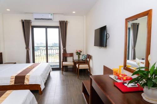a hotel room with a bed and a table and a mirror at WILD HORSE Hotel - Khách sạn biển Hải Tiến in Mỹ Ðuc