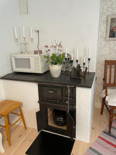 a kitchen with a counter with a microwave and candles at Trevligt eget hus med kakelugn i lantlig miljö in Vikingstad
