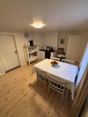 a kitchen and dining room with a white table and chairs at Trevligt eget hus med kakelugn i lantlig miljö in Vikingstad