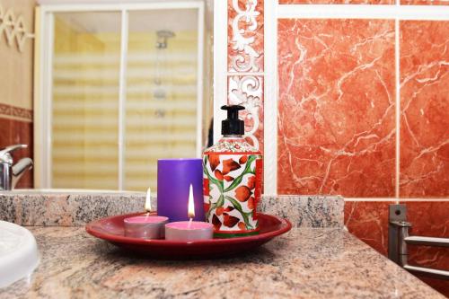 a bathroom counter with a bottle of perfume and candles at La Rondinella in Castellero