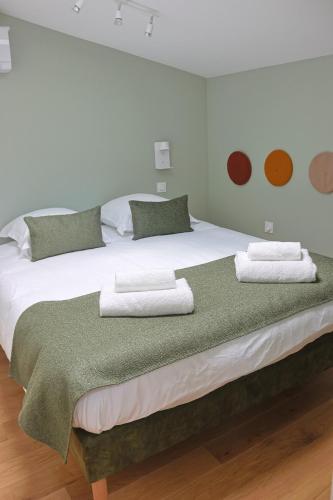 une chambre avec un grand lit avec des serviettes dessus dans l'établissement Le Castéja Chic - Elégance en Centre Ville, à Bordeaux