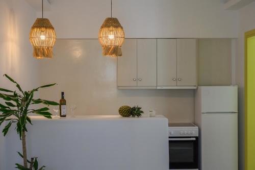 a kitchen with two pendant lights and a white refrigerator at New Earth in Kamari