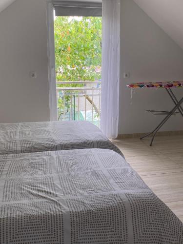 a white bedroom with a bed and a window at Apartma Azurre in Postojna