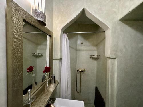 a bathroom with a shower and a sink and a mirror at Riad ART DE VIVRE avec Jacuzzi in Marrakech