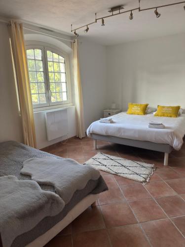une chambre avec deux lits et une fenêtre dans l'établissement Villa Domaine Font Mourier, à Cogolin