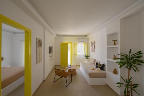 a living room with a yellow door and a couch at New Earth in Kamari