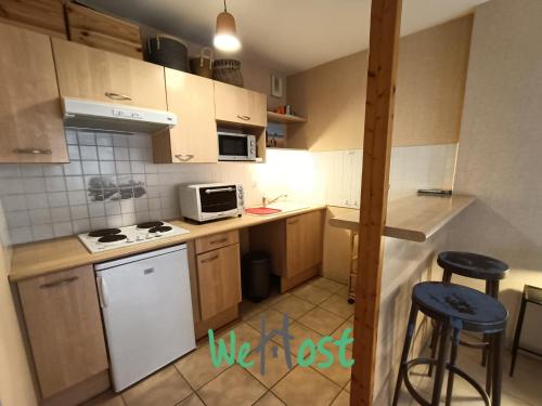 une petite cuisine avec une cuisinière et un micro-ondes dans l'établissement Studio with Balcony, à La Rochelle