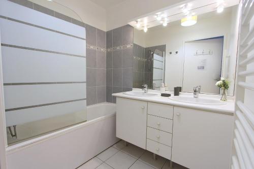 une salle de bain avec deux lavabos, une baignoire et un miroir dans l'établissement DANUBE4 Top floor apartment 6-8pers Disneyland, à Serris