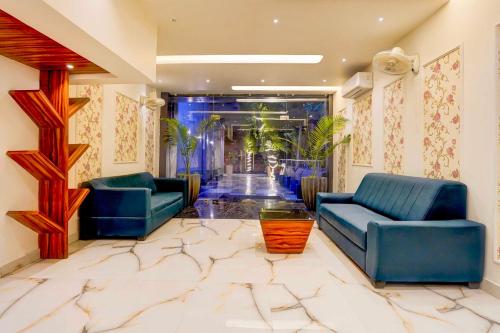 a lobby with two blue chairs and a marble floor at Townhouse Oak Alwar Railway Junction in Alwar