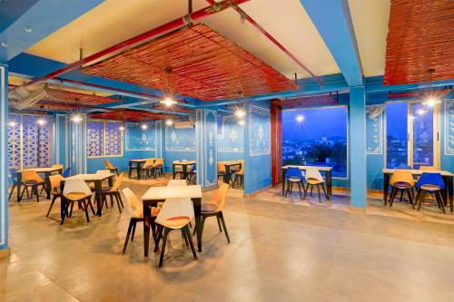 a restaurant with tables and chairs and blue walls at Townhouse Oak Alwar Railway Junction in Alwar