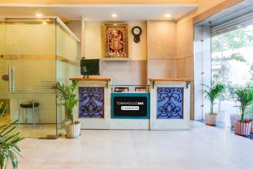 a lobby with a television and plants in a building at Townhouse Oak Udaipur City Railway Junction in Udaipur