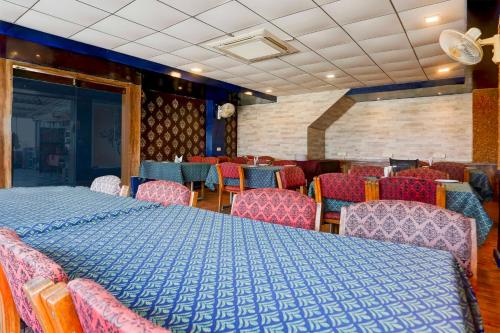 a dining room with a blue table and chairs at Townhouse Oak Udaipur City Railway Junction in Udaipur