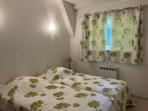 une chambre avec un lit et une fenêtre avec des rideaux dans l'établissement A L Ombre du Tilleul, à Tour-de-Faure