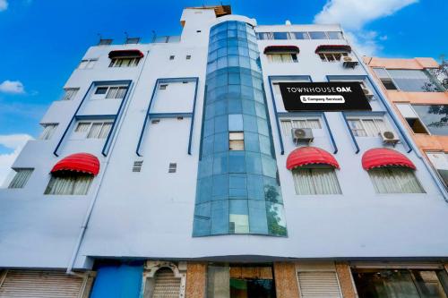 a tall white building with a sign on it at Townhouse Oak Udaipur City Railway Junction in Udaipur