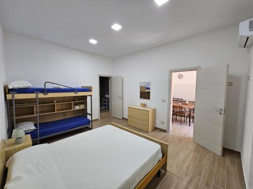 a bedroom with bunk beds and a dining room at Cavour Apartaments in Pachino