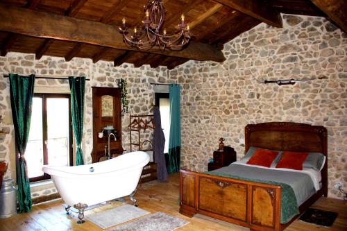 a bedroom with a bed and a bath tub at Nuit de Légende en Beaujolais in Lantignié-en-Beaujolais