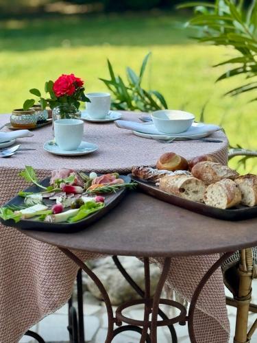 a table with a tray of bread and a plate of food at Les Jardins de Sitaara in Cucuron
