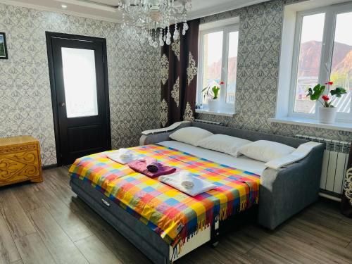 a bedroom with a bed with a colorful blanket at DADOW Guesthouse in Naryn