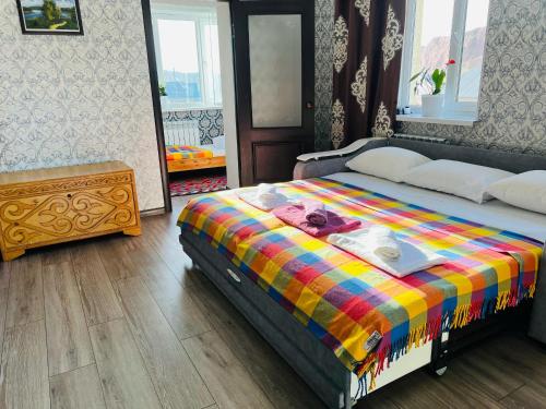 a bedroom with a bed with a colorful blanket at DADOW Guesthouse in Naryn