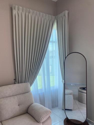 a living room with a couch and a large window at Villa Nurami in Malacca