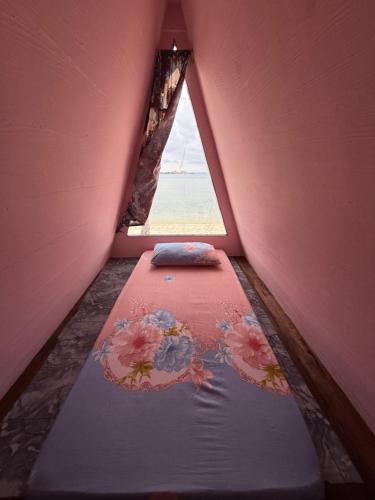 a small bed in a room with a window at Redang Campstay A Frame in Redang Island