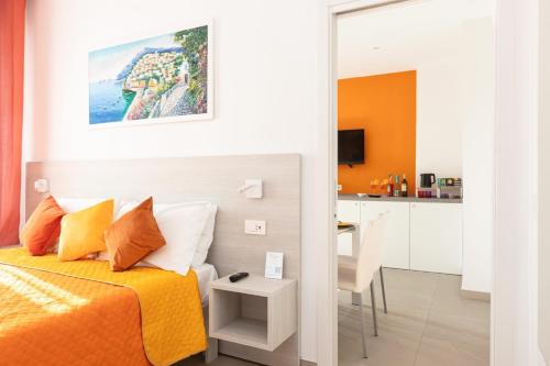a bedroom with a bed and a table and a kitchen at Orange y Lemon in Sant'Agnello