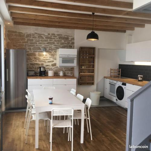 - une cuisine avec une table blanche et des chaises blanches dans l'établissement Soul Surfing Camp, à Plozévet