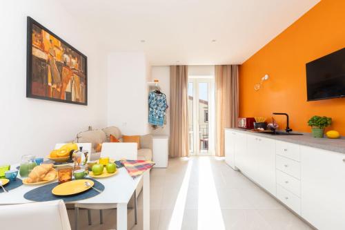 a kitchen with orange walls and a table with food on it at Orange y Lemon in Sant'Agnello