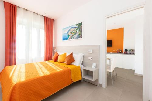 a bedroom with a bed with an orange blanket and a desk at Orange y Lemon in Sant'Agnello