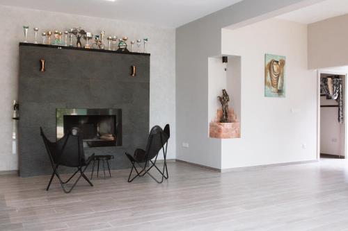 a living room with two chairs and a fireplace at Ride&Rest by Zabike in Prodromos