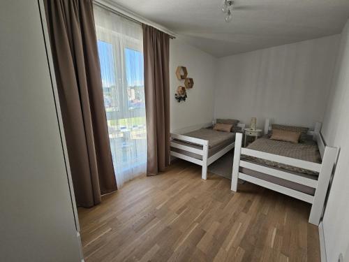a room with two bunk beds and a large window at Apartman 33 in Kiseljak