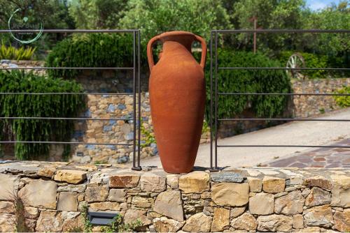 a large orange vase sitting on top of a stone wall at Anima Mediterranea in Albenga