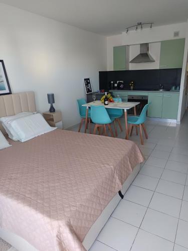 une chambre avec un lit et une table avec des chaises dans l'établissement Nice studio 5 minutes walk from the beach, à Cagnes-sur-Mer