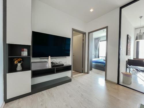 a living room with a flat screen tv on a wall at The Base Central Pattaya by WWC in Pattaya Central